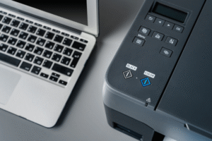 Laptop mit FaxSuite-Oberfläche neben Drucker – digitale Faxlösung im Büroalltag